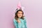 Little beautiful girl wearing cute easter bunny ears angry and mad raising fist frustrated and furious while shouting with anger