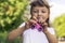 Little beautiful girl in white t-shirt is playing pink spinner in hand on the street