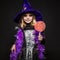 Little beautiful halloween witch with colorful candy