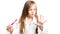 Little beautiful preschooler girl brushes her teeth with a pink toothbrush closing her eyes and holding out her hand with a