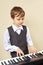 Little beginner pianist play the keys of electronic synth