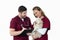 Little bichon dog sitting calm in nurse arms during vet examination