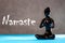 Little black figurine woman keep hands in Namaste - greeting sign. Yoga and meditation concept