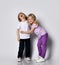 Little blond baby girl and boy friends or sister and brother in stylish clothes play smile tickle