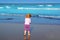 Little blond beach girl rear view sea turquoise