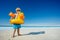 Little blond boy on the beach with inflatable yellow duck buoy