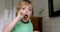 Little blond boy learning brushing his teeth