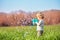 Little blond boy play soap bubbles stand at the spring field