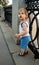 Little blond boy stands in a cast-iron fencing the waterfront and looking with interest