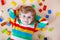 Little blond child playing with lots of colorful plastic blocks