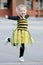 Little blond girl in bee costume dancing outdoors
