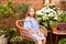 Little blond girl in blue dress sitting on the chair in the garden