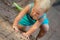 Little blond girl climbs on the ground