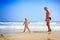 Little Blond Girl Grandpa Stand on Wet Sand by Wave Surf