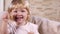 Little blond girl laughing in front of the camera