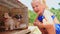 Little Blond Girl with Pigtail Watches Puppies in Cage