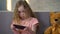 Little blond girl playing game on smartphone, gadget addiction, childhood