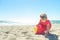 Little blond girl in red dress on the beach