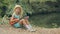 Little blond girl in a straw hat sitting near the