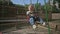 Little blond girl swinging on swing at playground