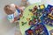 Little blond kid boy playing with lots of colorful plastic block