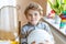 Little blond preschool kid boy with air balloon ball