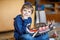 Little blond preschool kid boy playing with toy ship indoors