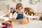 Little blond toddler boy child with sister, preparing dough for easter brioche buns, sweet easter bread with nuts and dry fruits