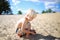 Little Blonde Boy Collecting Rocks and Shells at Beach on Summer
