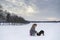 Little blonde caucasian Swedish girl playing and cuddle puppy dog in winter landscape