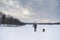 Little blonde caucasian Swedish girl running and playing with dog in winter landscape