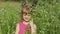 Little blonde child girl in pink dress stay on flower chamomile grass meadow. Bouquet of daisies