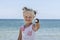 Little blonde girl on the beach holds in her hand chocolate ice cream