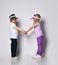 Little blonde girl and boy in colorful casual clothes and sun visors. Smiling, looking at each other, posing isolated on white