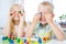 little blonde girl and boy have fun, laugh and indulge playing board game. Hold people figures in hands like their eyes. yellow, b