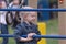 Little blonde girl in denim jacket on sports field. Portrait of child on the childrens playground