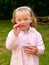 Little blonde girl eating strawberries