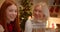 Little blonde girl hugs red-haired sister at Christmas family gift dinner evening