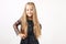 Little blonde girl with long golden hair wearing black dress with stars & planets, dancing, smling & having fun, white wall backgr