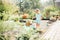 Little blonde girl playing at garden with water in a tin basin. Kids gardening. Summer outdoor water fun. Childhood in the country