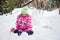 Little blonde girl playing in the snow