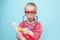 Little blonde girl with red glasses listen heart with stethoscope.