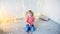 Little blonde girl sits on floor in room with new year`s decor.