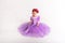 Little blonde girl wearing purple fairy princess dress on white background. Kids costume for new year party