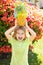 Little blonde kid hugging pineapple on nature background. Childhood, healthy nutrition, advertising. Close up kids funny