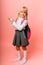 Little blonde schoolgirl points advertisement, solution promotion, isolated on yellow background