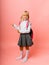 Little blonde schoolgirl points advertisement, solution promotion, isolated on yellow background