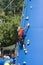 Little blondie girl training on an outdoor climbing tower