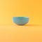 Little blue bowl on ocher and orange background with copy space. Advertisement idea. Minimal banner ad concept