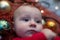 Little blue eyed baby lying in a Christmas cot